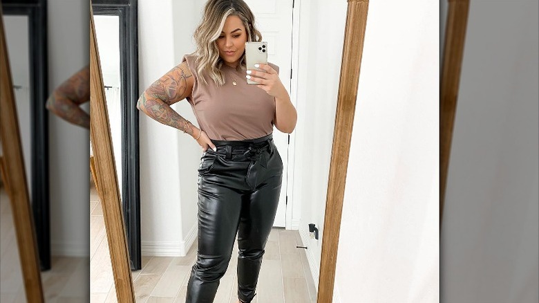 Woman takes mirror selfie in muscle tank