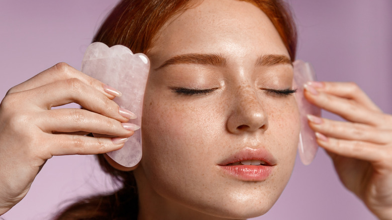 woman rolling gua sha