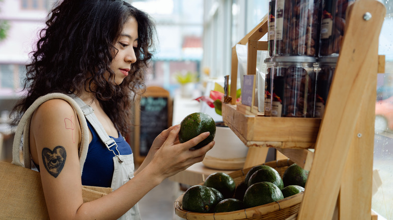 woman holding avocado