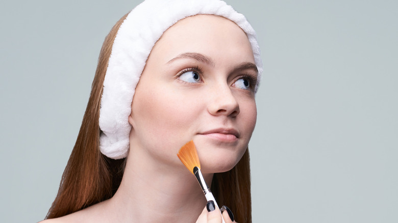 Woman applying an exfoliant.