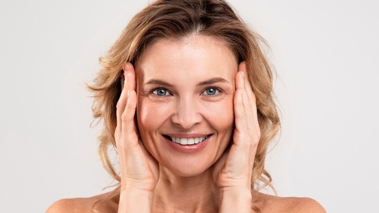 smiling woman touching face