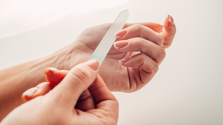 person using a cyrstal nail file