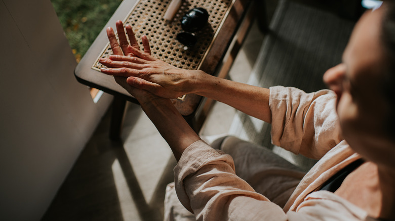 A woman rubbing cream into her hands.