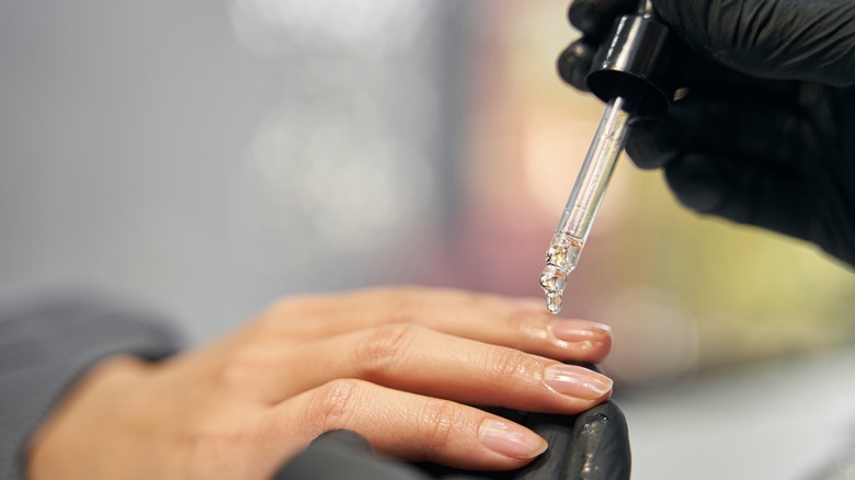 Nail tech applying cuticle oil