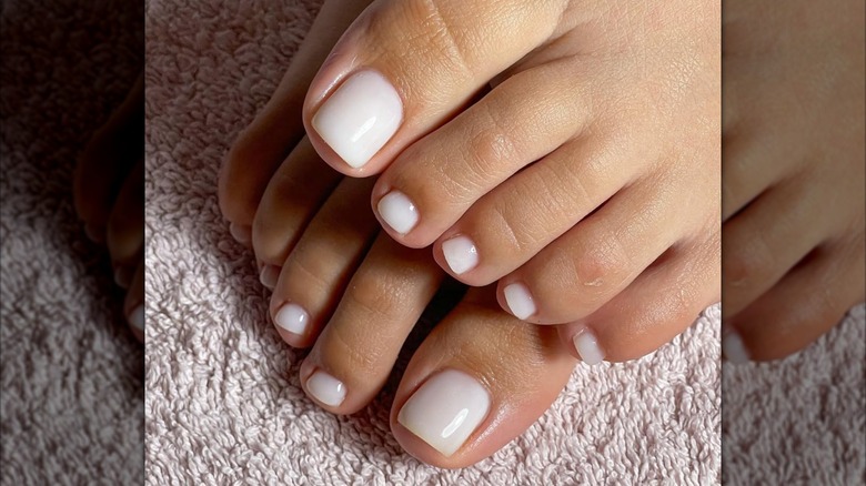 Pedicure with milky white nail polish.