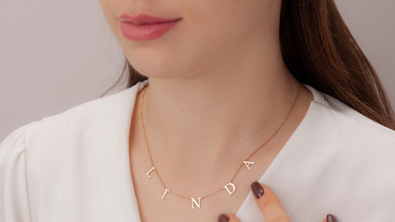 woman wearing pendant nameplate necklace