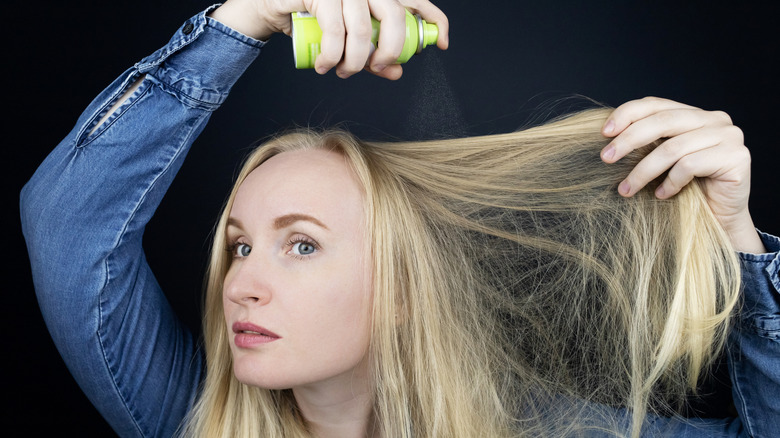 woman spritz dry shampoo 