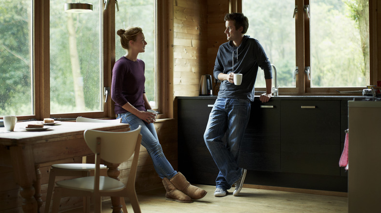 Couple converses in the kitchen