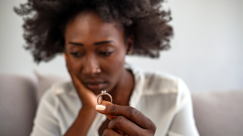 sad woman holding ring