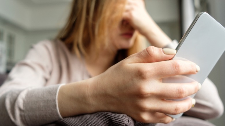 Sad woman holding phone