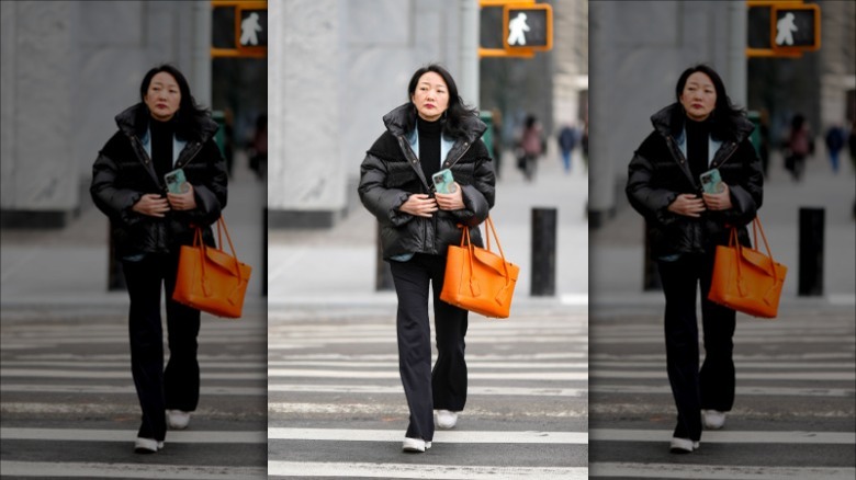 woman holding neon orange tote 