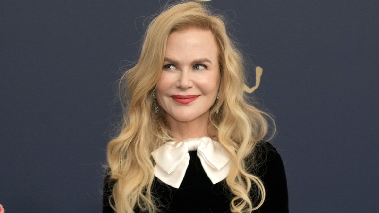 Nicole Kidman posing in a voluminous blond wig with a deep side part