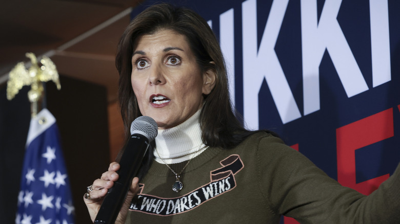 Nikki Haley on stage wearing a sweater reading "She who dares wins."