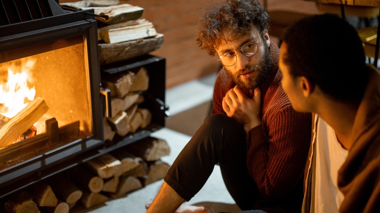 gay couple talking by fire