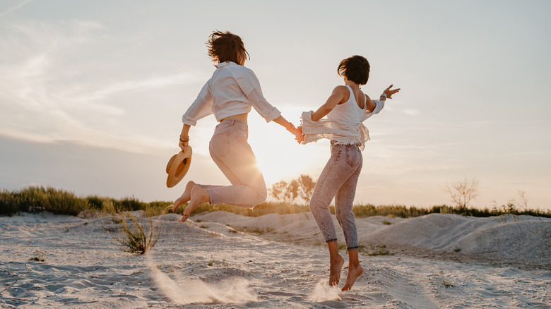 Two women jumping at beach