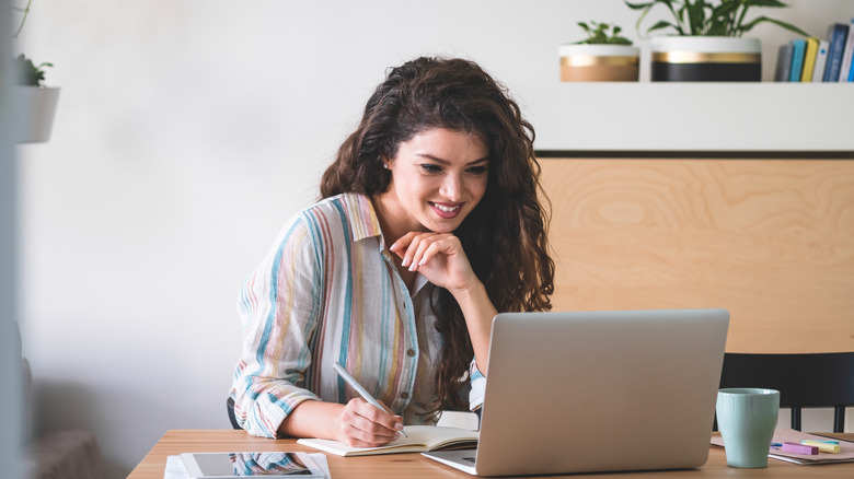 Woman studies chart on laptop