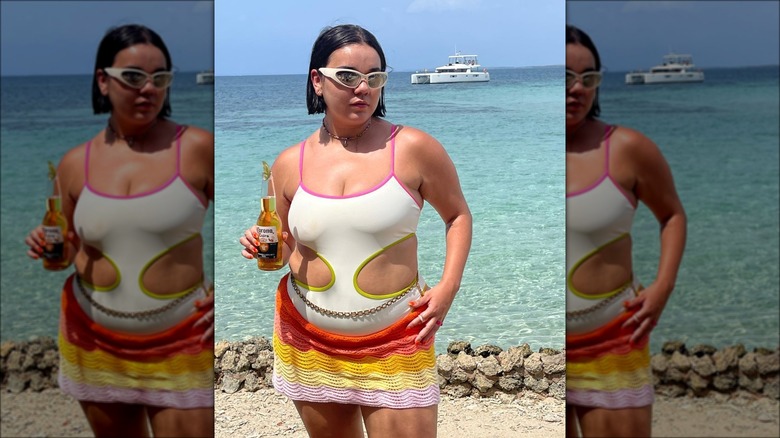 Woman wearing white bathing suit with two-sided cutouts