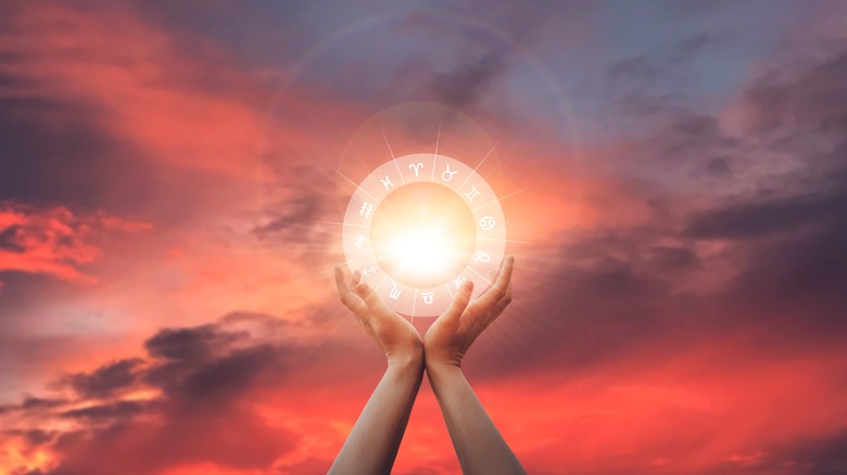 picture of woman holding up zodiac wheel