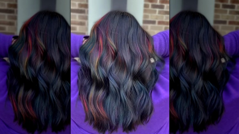 Someone shaking their oil slick waved hair