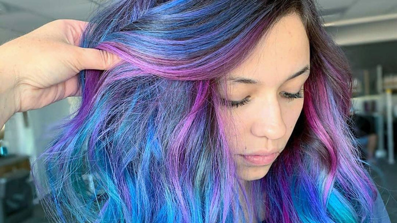 A woman posing with oil-slick hair