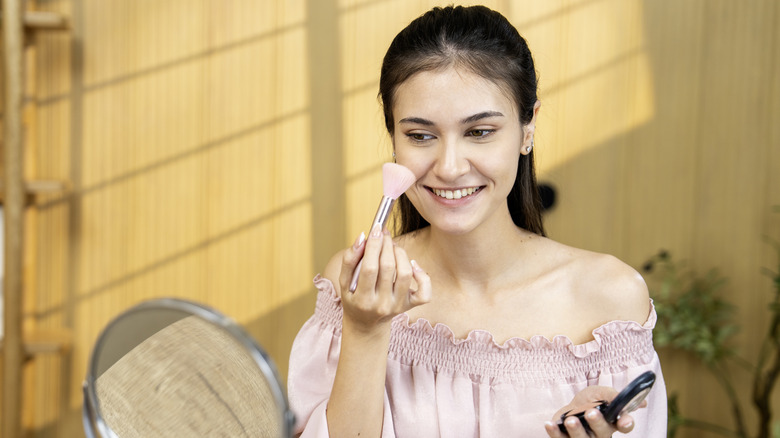 Woman powdering her face