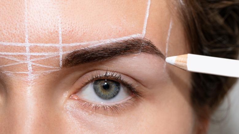 woman getting face mapped before permanent makeup