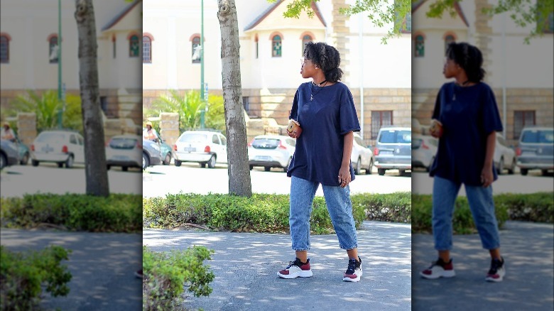 Girl wearing oversized t-shirt and baggy denim with dad sneakers.
