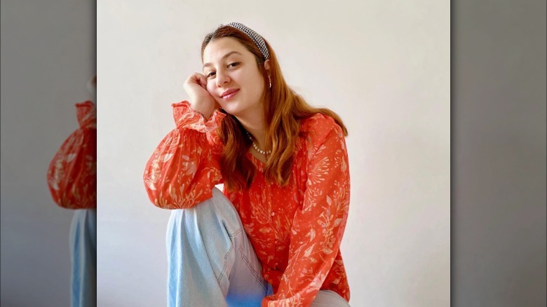 Girl wearing denim with orange blouse