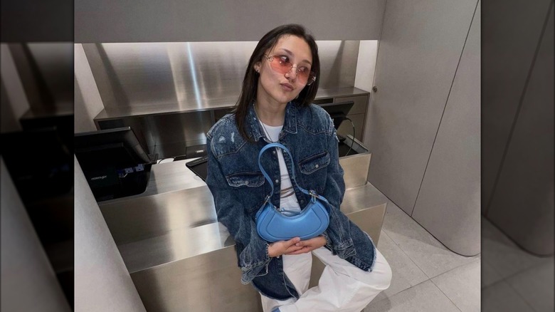 Woman with blue curved handbag