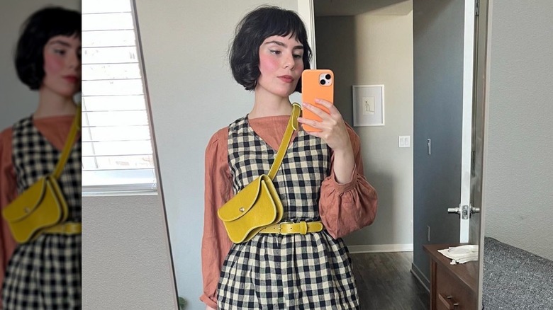 Woman in plaid with curved shoulder bag