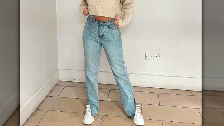 Split-hem jeans and white sneakers