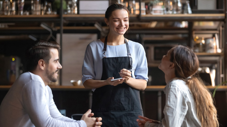Smiling waitress taking an order