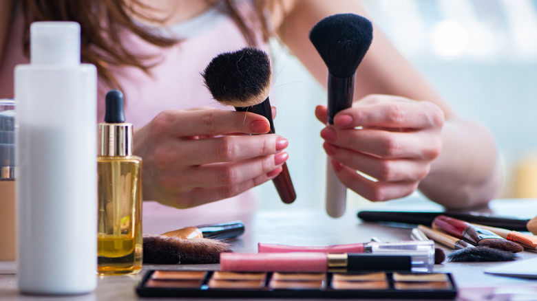 Close up of hands holding makeup brushes