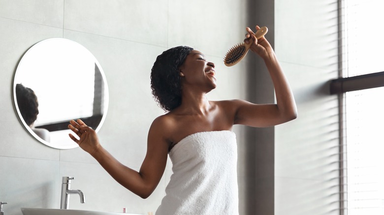 woman singing into hairbrush