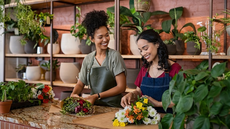 Two women talking and wrapping flowers