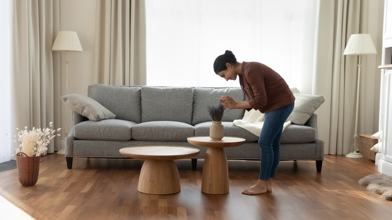 Woman tidying up living room