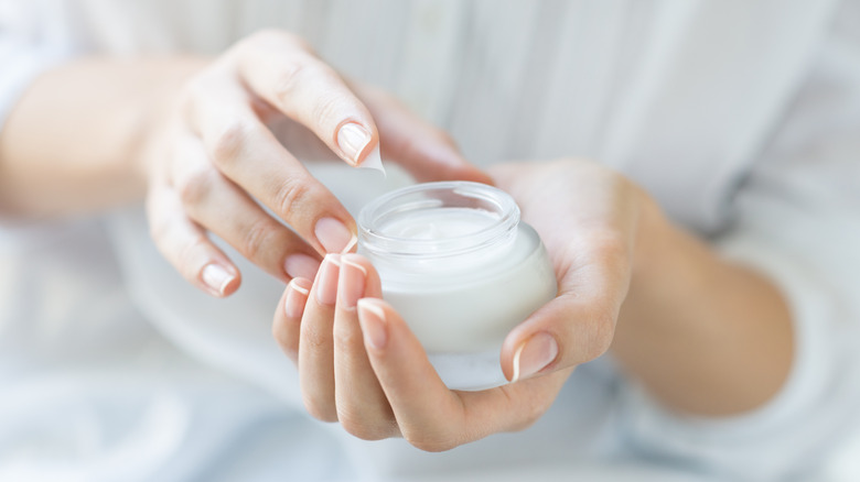 Woman holding jar of moisturizer