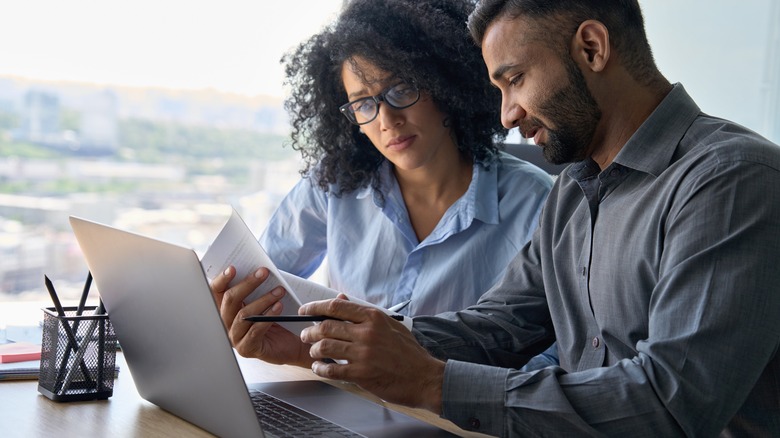 Two people looking at papers