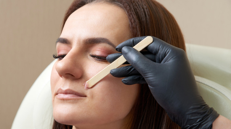 A middle-aged woman having her upper lip waxed