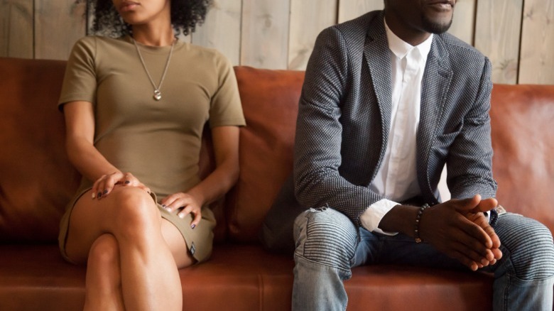 Black couple sitting on couch