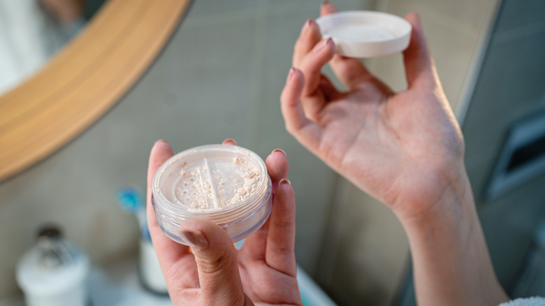 woman holding loose powder foundation