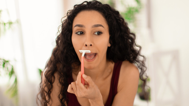 A woman shaving her face