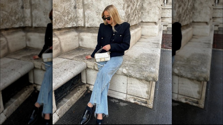 Woman wears frayed jeans with high-end jacket