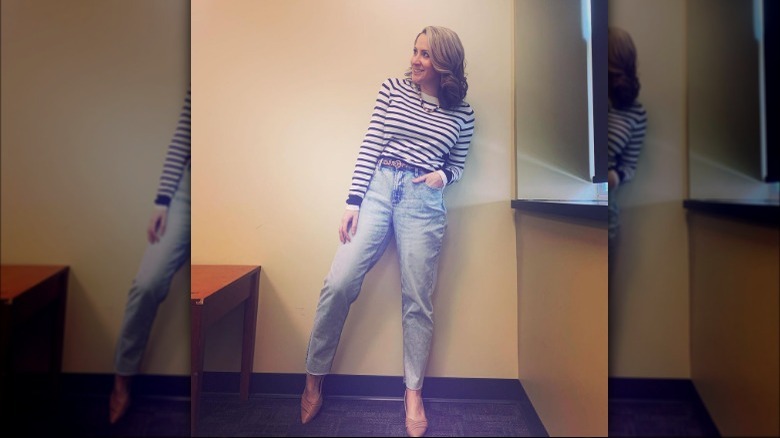 Woman poses in jeans and sweater 