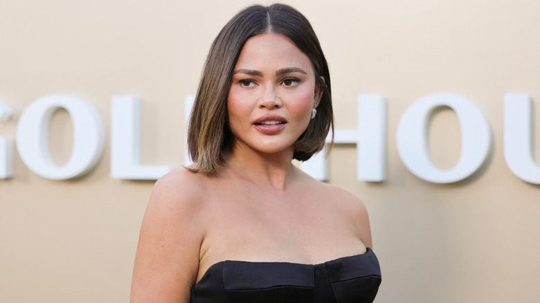 Chrissy Teigen wearing black dress with bob.