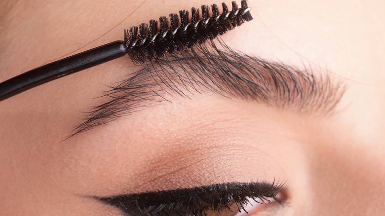 spoolie combing woman's eyebrow