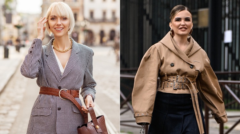 A woman wearing a blazer and statement belt next to a woman wearing double belts over a tan jacket