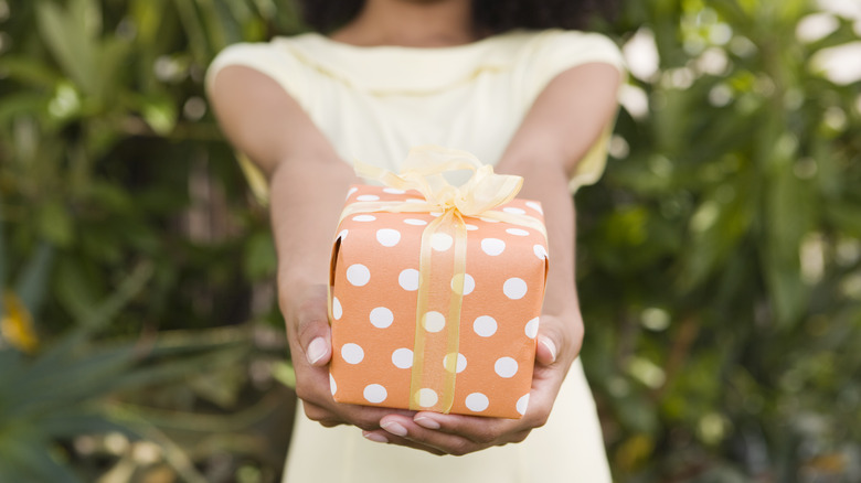 Woman holding an orange present