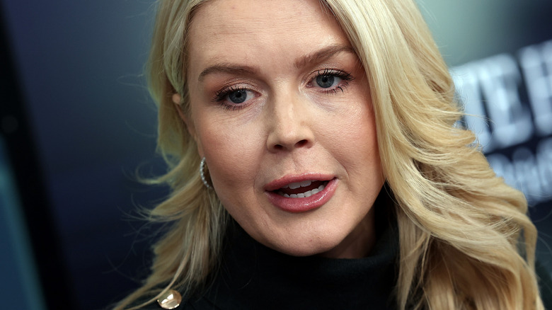 Karoline Leavitt in a black outfit speaking to reporters