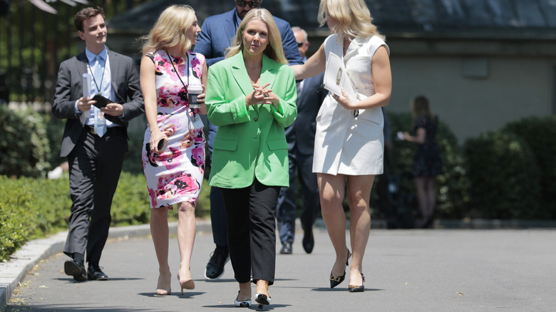 Karoline Leavitt wearing an ill-fitting green blazer with shoes that don't match